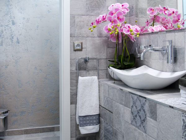 design interiéru koupelny s použitím antické zeminy, stříbrnomodrých obkladů a designových umyvadel.